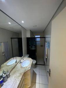 蒙加瓜Apartamento Mongaguá的一间带两个盥洗盆和大镜子的浴室