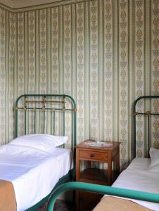 伊普尔Barak de Vinck的一间卧室配有两张床和一个带桌子的床头柜。