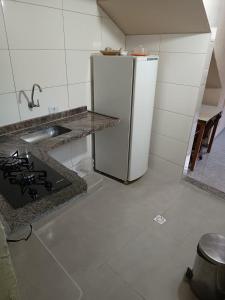 圣托梅-达斯莱特拉斯Suites em São Thomé das Letras的厨房配有白色冰箱和水槽