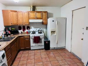 圣安娜Zen Home的厨房配有木制橱柜和白色冰箱。