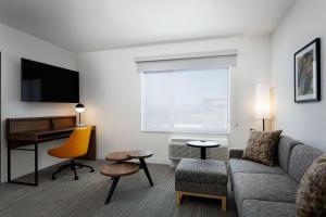 桑顿TownePlace Suites by Marriott Denver North Thornton的带沙发和书桌的客厅