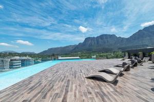 开普敦Rooftop with breathtaking views of Table Mountain.的一座建筑屋顶上带躺椅的游泳池