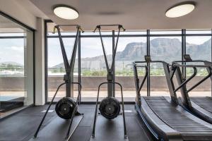 开普敦Rooftop with breathtaking views of Table Mountain.的健身房设有两个跑步机和大窗户