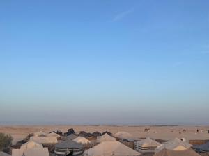 SabriaLuxury Camp Dunes Insolites Sabria的一群人背景在沙漠中的帐篷