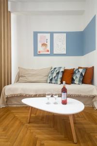 雅典KUKAKI ESTATE 2的客厅配有沙发和带2个酒杯的桌子