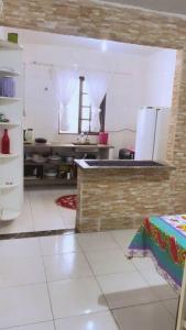 大普拉亚Seu Cantinho na Vila Tupi 3 Dormitórios的厨房配有柜台和冰箱。
