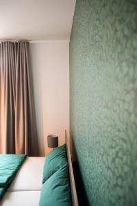 梅尔布施Green46的一间卧室设有一张床和绿色的墙壁