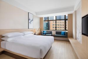 上海上海浦东中心万枫酒店的卧室设有白色的床和大窗户