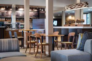 尔湾欧文约翰韦恩机场奥兰治县万怡酒店的一间带桌椅的餐厅和一间酒吧