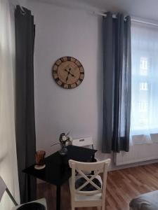 卡托维兹Cozy Apartments and Rooms Katowice的墙上有桌子和时钟的房间