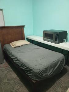 蒙特雷Recamara confortable en San Nicolás的一张位于一个配有微波炉的房间里的床