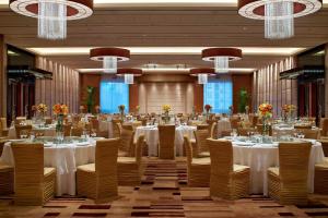 北京北京海淀永泰福朋喜来登酒店的宴会厅配有白色的桌椅和吊灯