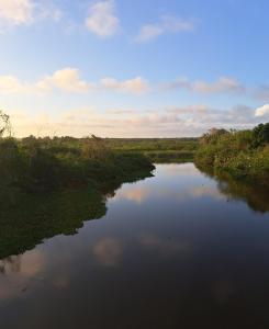 伊塔乌纳斯ITAÚNAS Pousada Nossa Palhoça的田野中河流的空中景观
