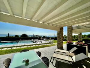 莫尼加La Giolosa Gardapartments的一个带桌椅的庭院和一个游泳池