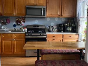布鲁克林Classical American House 4的厨房配有木制橱柜、炉灶和木桌。