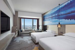 昆明昆明德尔塔酒店的酒店客房设有两张床,墙上挂着一幅大画。