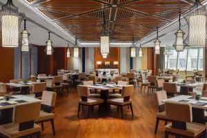 银川银川万怡酒店的用餐室配有桌椅和吊灯。