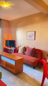 斯希拉特Plage Skhirat appartement amis et familles的客厅配有红色沙发和电视