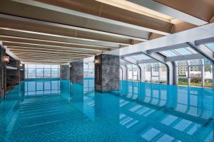 昆明昆明喜来登酒店的一个带蓝色地板和窗户的游泳池