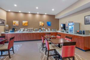 布朗斯堡Comfort Suites West Indianapolis - Brownsburg的一间带桌椅和柜台的餐厅