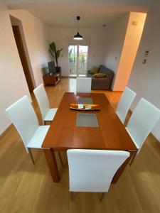 格拉纳达APARTAMENTO GOR的一间带木桌和白色椅子的用餐室