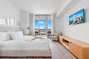 好莱坞Modern 2 bed at Beach Walk 17th floor Miami的白色的卧室设有床和窗户