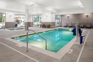 波蒂奇SpringHill Suites by Marriott Kalamazoo Portage的一座配有桌椅的酒店游泳池