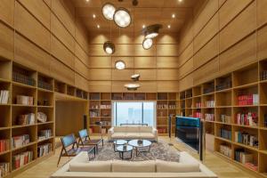 郑州郑州建业艾美酒店的客厅配有书架和沙发