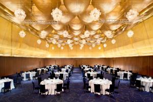 郑州郑州建业艾美酒店的宴会厅配有白色桌子和黑色椅子