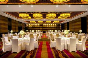北京北京威斯汀酒店的宴会厅配有白色的桌椅和吊灯