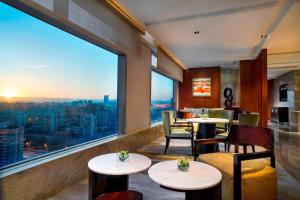 北京北京金隅喜来登大酒店的餐厅设有桌椅和大窗户。