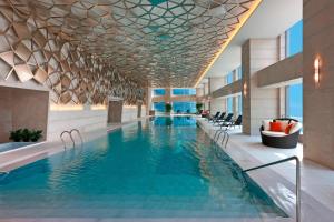 北京北京金隅喜来登大酒店的一座带椅子的酒店游泳池,一座建筑