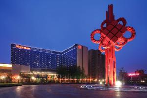 合肥合肥新站利港喜来登酒店的一座大型建筑,前面有大红雕塑