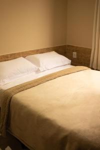 弗洛里亚诺波利斯Chalé 31的一张配有白色床单和枕头的大床