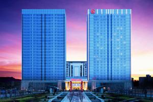 胶州青岛胶州绿城喜来登酒店的日落时分在城市里两座高耸的摩天大楼