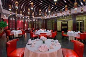 福州福州中庚喜来登酒店的用餐室配有桌子和红色椅子以及桌上桌