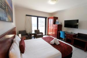 洛坎普顿咖啡馆公寓汽车旅馆的酒店客房配有一张床、一张书桌和一台电视。