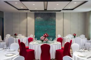 天津天津陆家嘴万怡酒店的一间会议室,配有白色的桌子和红色的椅子