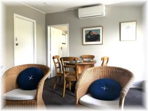Pukerua BayPeaceful Pukerua Bay的用餐室配有藤椅和桌子