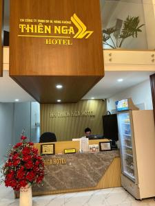 Buôn Alê (1)THIÊN NGA HOTEL的接待台,有坐在酒店的男人