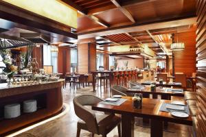 温州温州喜来登酒店的一间带木桌椅的餐厅和一间酒吧