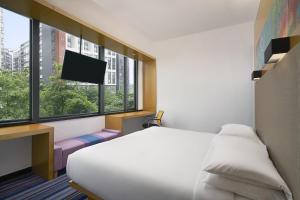 广州Aloft Guangzhou University Park的一间酒店客房,配有一张床和一台电视