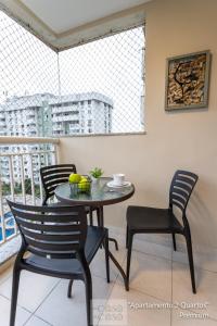 里约热内卢2 QUARTOS com Varanda a 300m RioCentro - CONDOMINIO com PISCINA, Estacionamento e Portaria 24h - Area de LAZER tambem para CRIANCAS - Wi-Fi 120mbps e Cozinha Completa的带阳台的客房内的桌椅