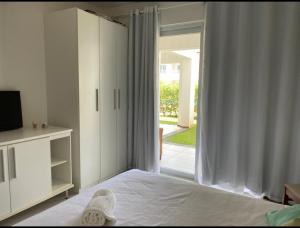 苏巴乌马Apartamento Master VIP com 3 suítes noTree Bies Resort的一间卧室设有一张床和一个滑动玻璃门