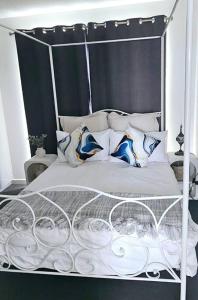 圣雷莫San Remo Coastal Apartment的一张带金属框架和枕头的白色床