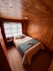 卡斯特鲁Hostal Magia Chilota的小屋内的小房间,配有一张床