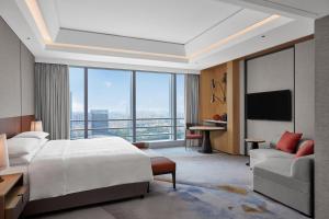广州Sheraton Guangzhou Panyu的酒店客房设有一张床和一个大窗户