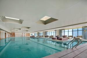 溧阳溧阳万豪酒店的一座大型游泳池,位于一座带窗户的建筑内