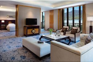 五台五台山万豪酒店的带沙发的客厅和带电视的客房。