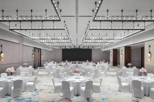 太原太原万怡酒店的宴会厅配有白色的桌椅和灯
